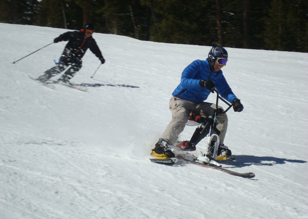 A former ski racer and adaptive skier, riding his iSkibike, races a skiing buddy down the mountain at Copper Mountain, near Silverthorne, Colorado..