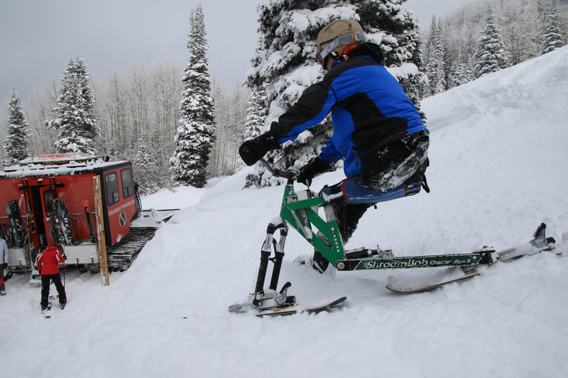 An adaptive ski biker, cruising down to the snow cat, can't wait for more deep powder skiing on his iSkibike with the Steamboat Powder Cats, Steamboat Springs, Colorado.