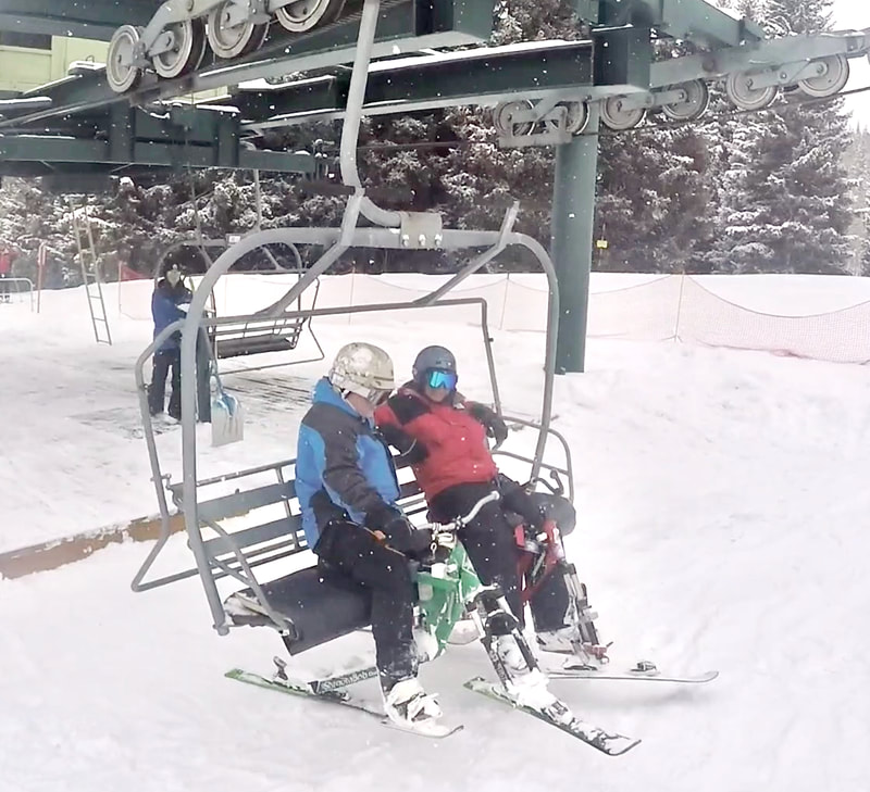 Two ski bikers loading their iSkibikes onto a Steamboat ski resort chairlift, Steamboat Springs, Colorado.