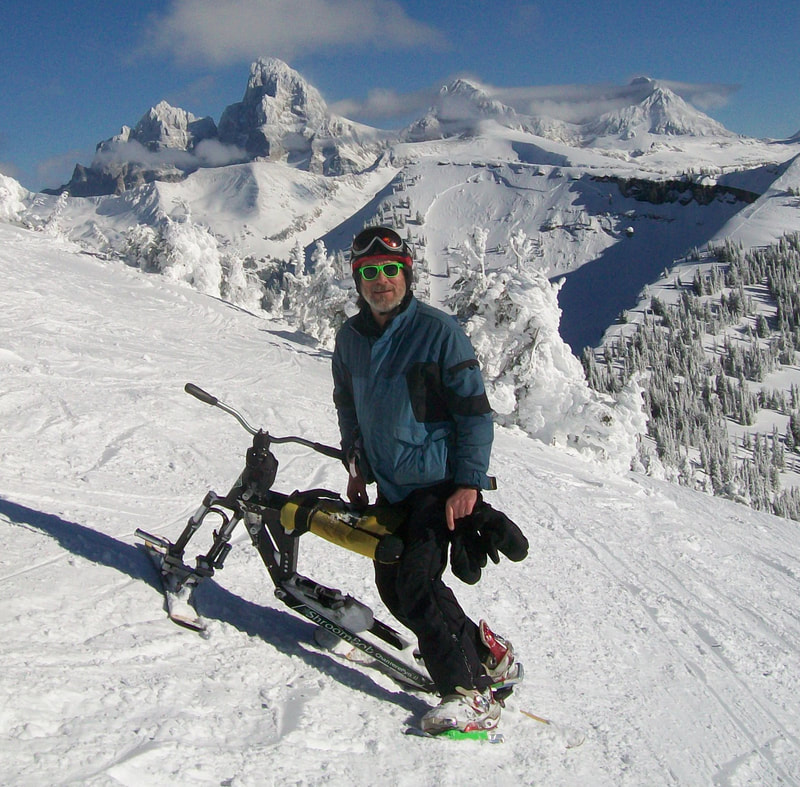 Getting ready to cruise the 'crud', on his iSkibike , a ski biker poses in front of the three Tetons, at the top of Crazy Horse, Grand Targhee Ski Resort, Alta, Wyoming.