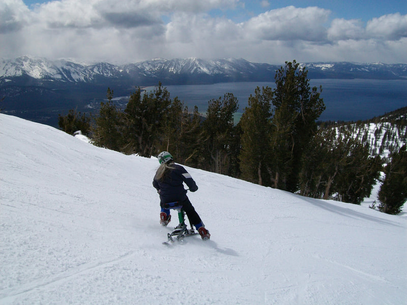 An adaptive ski biker, cruises her iSkibike down Ridge Run at the Heavenly Mountain Resort, aims for the shore of Lake Tahoe, South Lake Tahoe, California. 